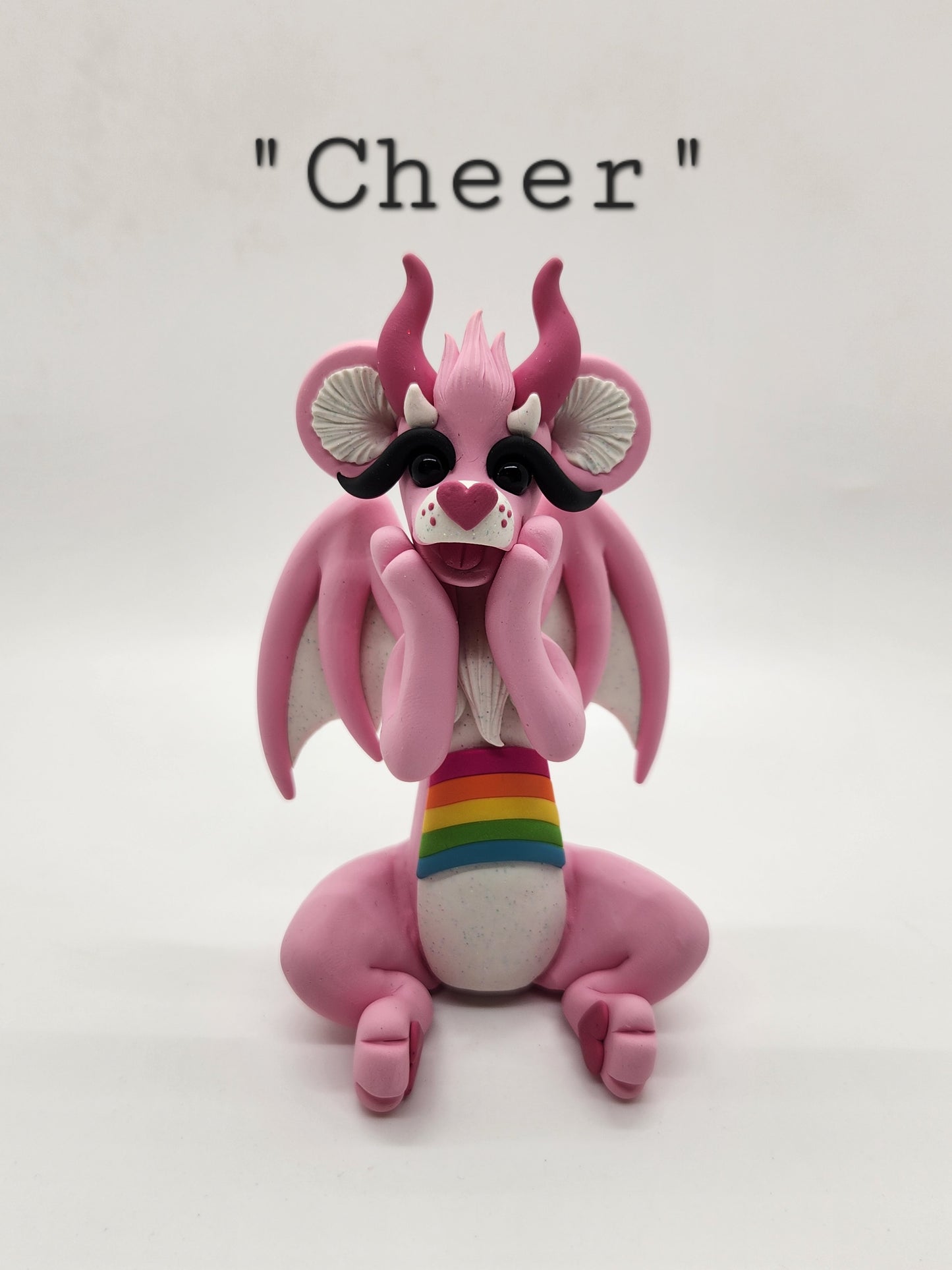 "Cheer" pink and rainbow care bear dragon sculpture