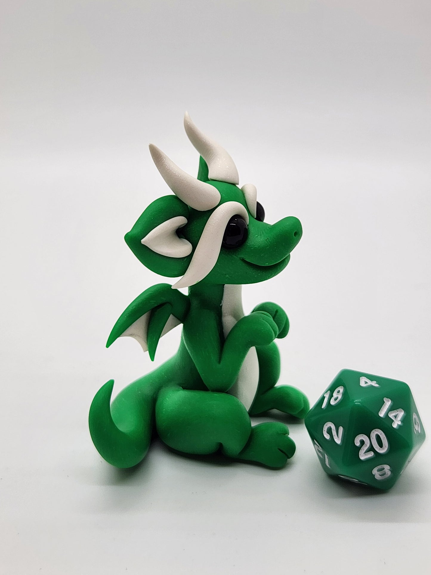 "Pito" green squish baby dragon sculpture with d20